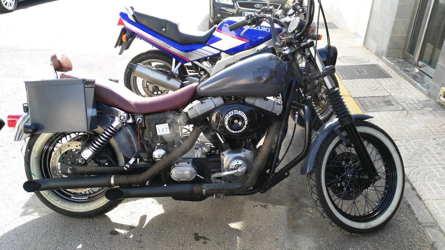 Lateral Dyna con escapes humeando y cinta anticalórica bronce